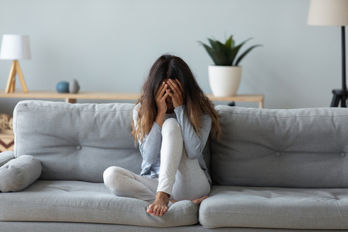 Frustrated,Woman,Covering,Face,And,Crying,,Sitting,On,Couch,At