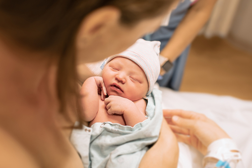 Mother,Holding,Her,Newborn,Baby,Girl,In,Her,Arms,Moments