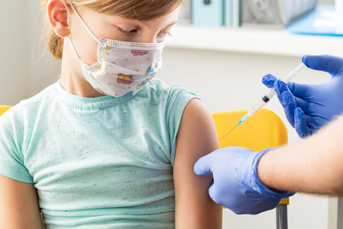 Little,Girl,In,Face,Mask,In,Doctor’s,Office,Is,Vaccinated.
