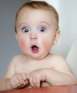 Surprised,Kid,Sitting,At,Table.,Child’s,Eyes,Widened,And,Mouth